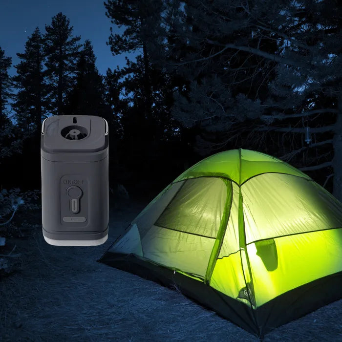 rechargeable air pump next to glowing tent at night in a forest campsite under trees