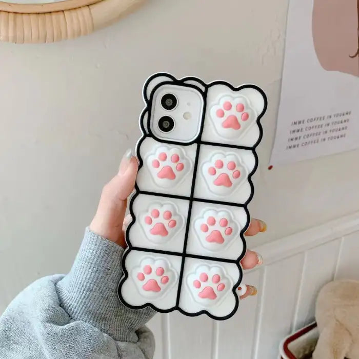 3D silicone phone case with white background and pink cat paw prints in grid pattern creating cute protective iPhone cover