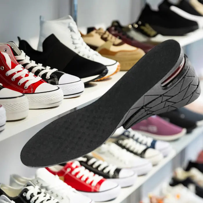 Adjustable height insoles shown with casual canvas sneakers in a trendy footwear store.