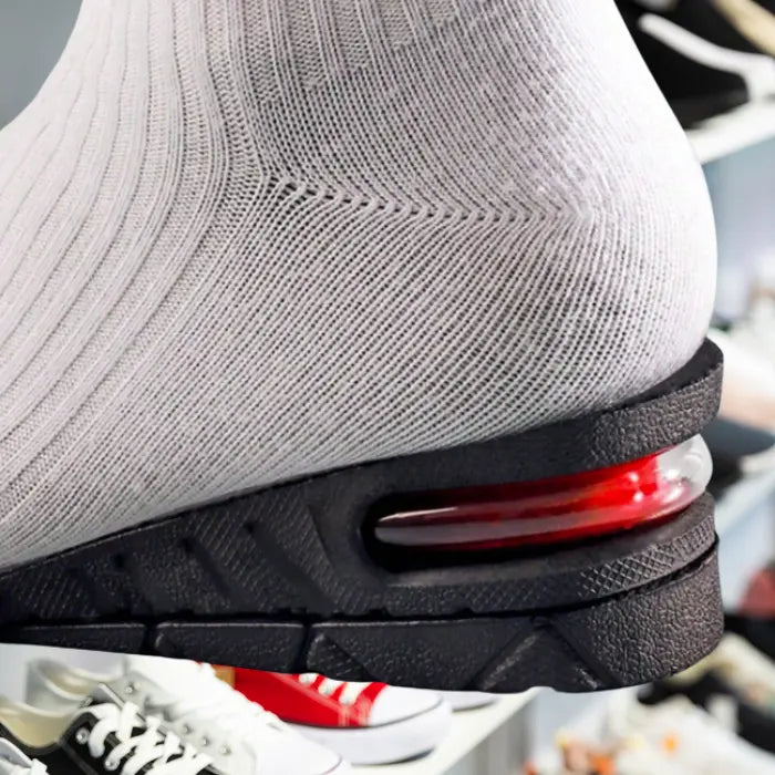 Adjustable height insoles worn under white sock showcasing discreet heel lift inside shoes.