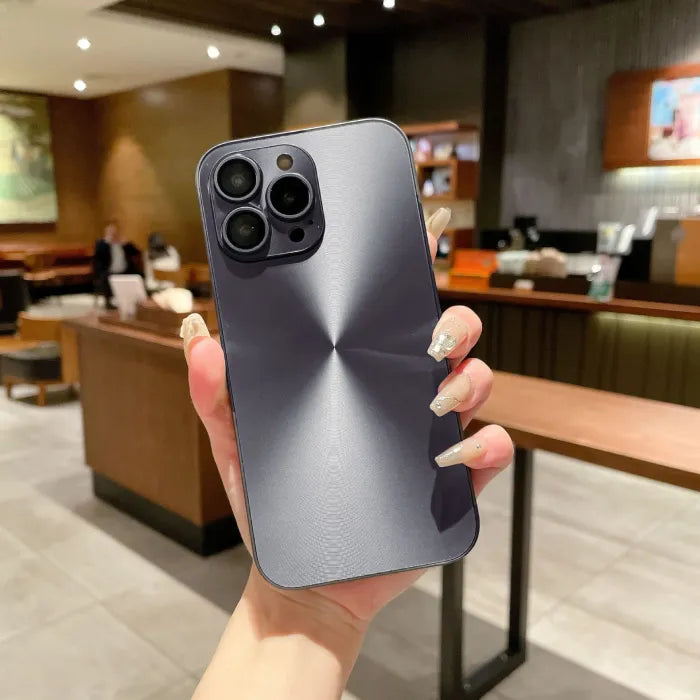 Midnight black anti smudge iPhone case with brushed finish held in hand at café setting.
