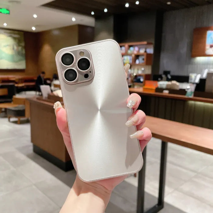 Pearl white anti smudge iPhone case held in hand with metallic swirl design in coffee shop.
