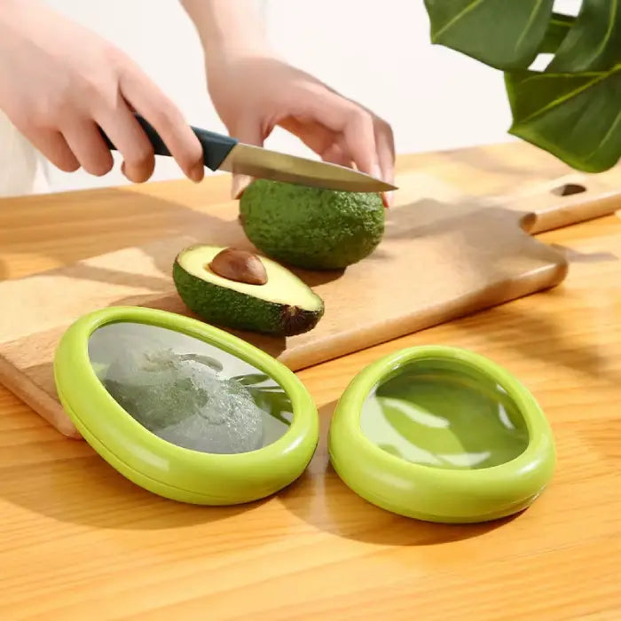 avocado storage container demonstration showing cutting process and green protective holder on wooden cutting board