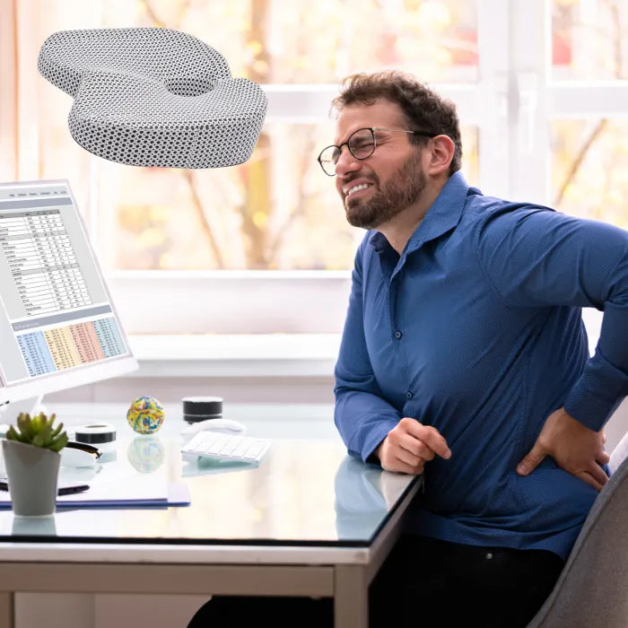 Office worker experiencing back pain relief benefits of orthopedic seat cushion during work