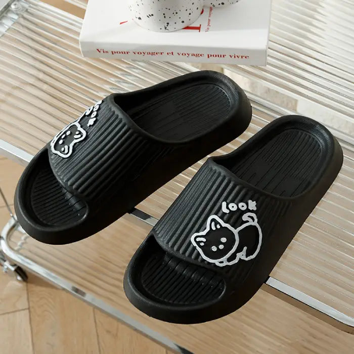 Black bathroom slides with white cartoon cat illustration against decorative background
