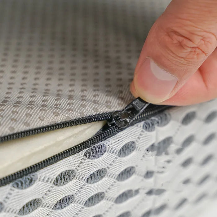 Close-up view of orthopedic cushion showing removable mesh cover with zipper for easy maintenance