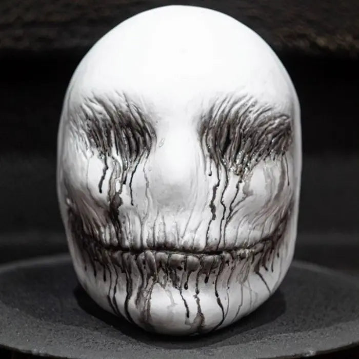 Ghost latex mask in full front view on display, showing dripping black paint from eyes and mouth.
