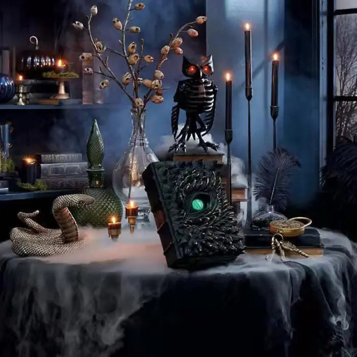 Halloween Decor book of dragons in gothic decor setup with candles, skulls, and eerie fog effects.