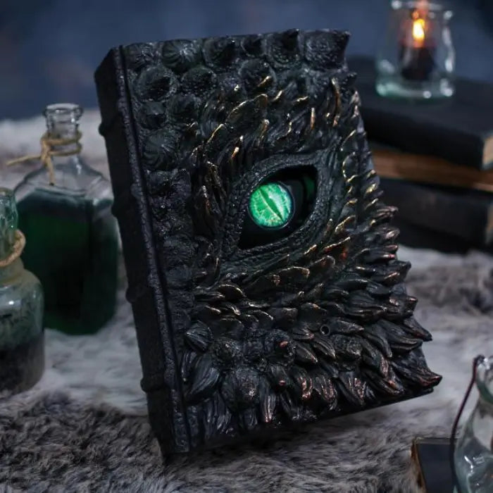 Halloween Decor book of dragons beside potion bottles on faux fur surface with mystical vibe.