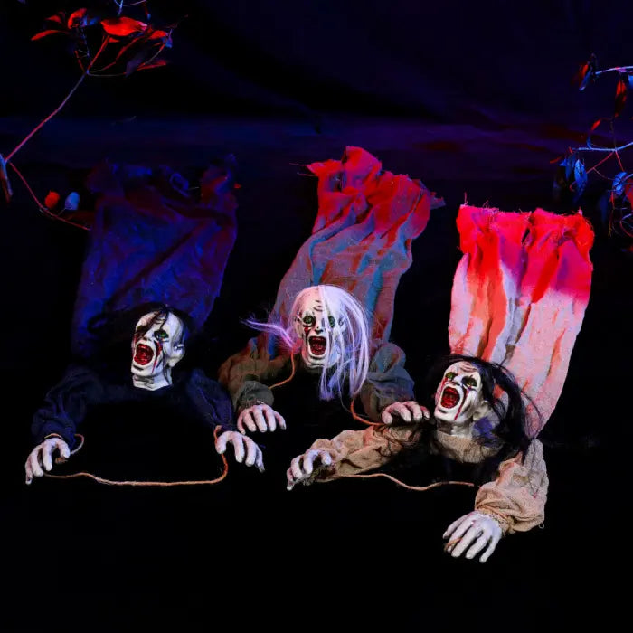 Halloween Decor Hanging Ghouls on ground posed crawling with outstretched arms and horror expressions.