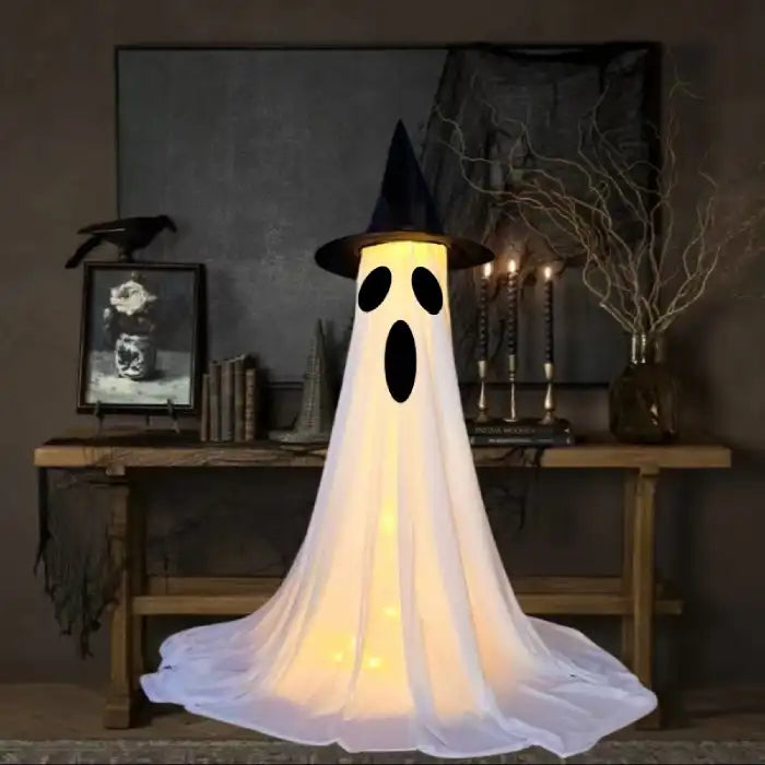 Halloween Ghost Yard Decor with long oval mouth and scared face glowing in Halloween home setting.