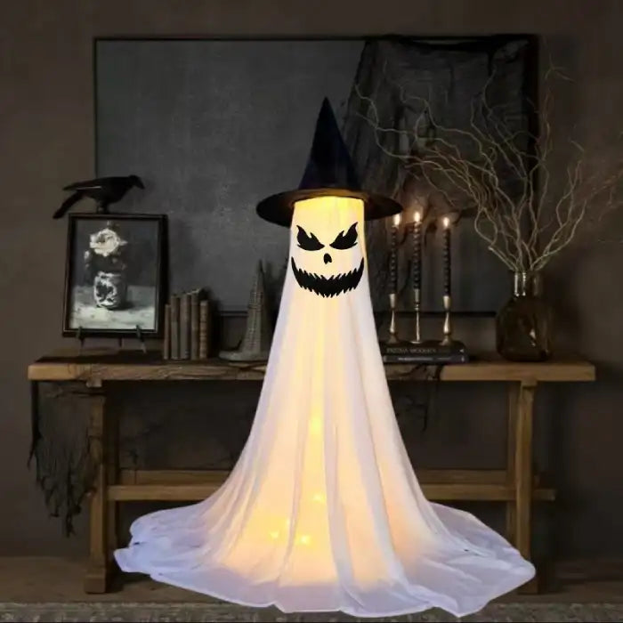 Halloween Ghost Yard Decor with black witch hat and scary glowing face in spooky indoor scene.