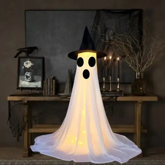Halloween Ghost Yard Decor glowing ghost with surprised face wearing a witch hat in haunted setup.