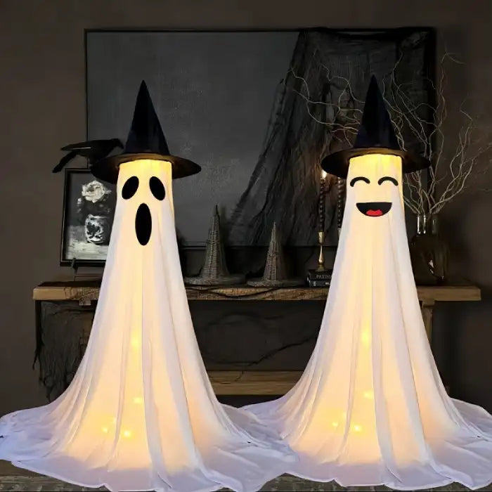 Halloween Ghost Yard Decor duo with light-up faces and witch hats inside spooky indoor display.
