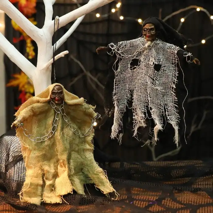 Halloween Hanging Ghost set in yellow and white, suspended on white tree with eerie netting and chains.
