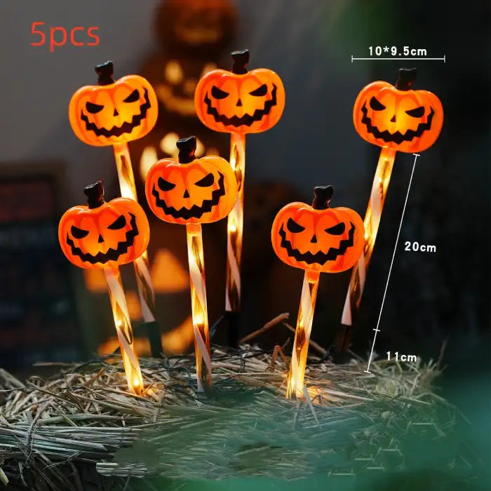 Halloween Pumpkin LED lights with single jack-o'-lantern face glowing orange in outdoor yard setting