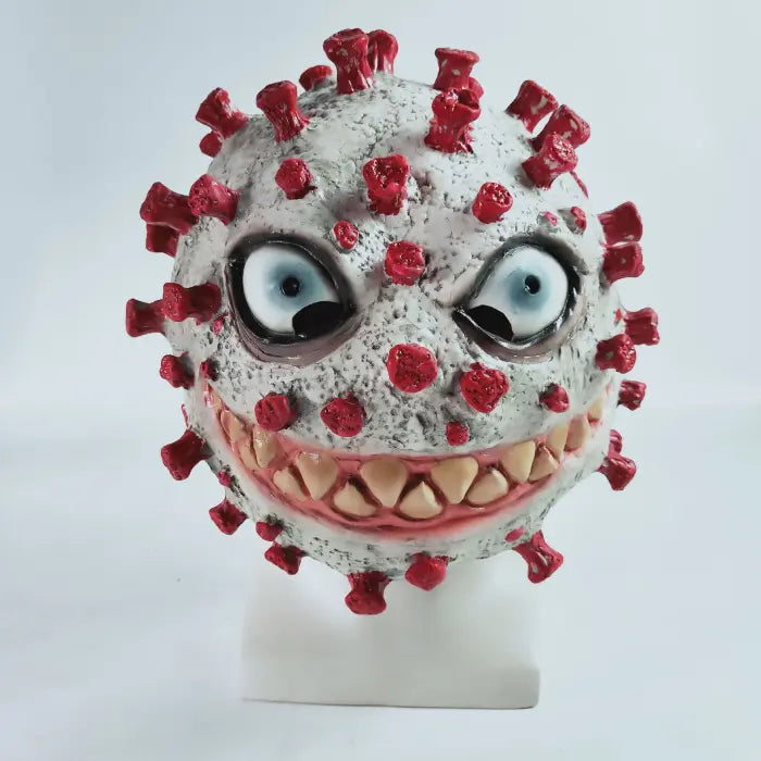 Halloween virus costume mask with evil grin, blue eyes, sharp teeth, and red spikes on gray base.