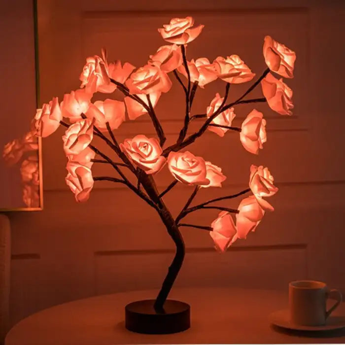 LED tree lamp in dark setting with glowing red rose bouquet on a black stand for home ambiance lighting.