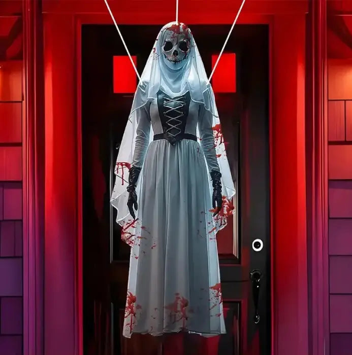 Life size Halloween prop of bloody ghost bride in white dress with skull face hanging at front door.