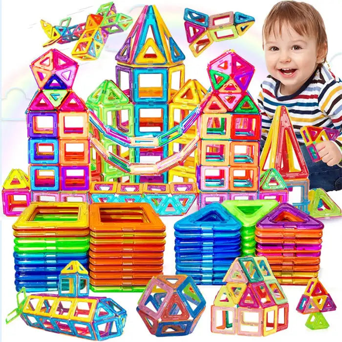 Magnetic building blocks used by toddler to build colorful geometric castle tower with smiling expression