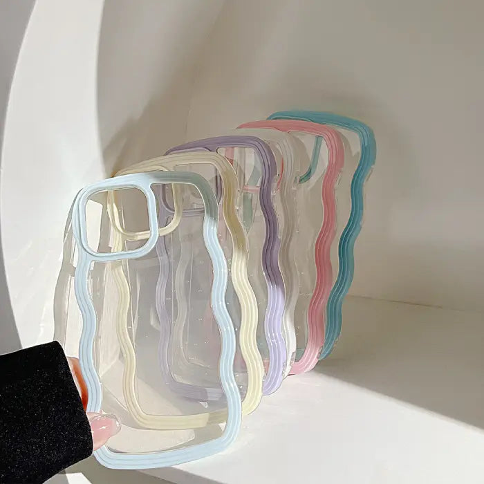 A collection of pastel-colored wavy-frame phone cases displayed on a curved white surface.