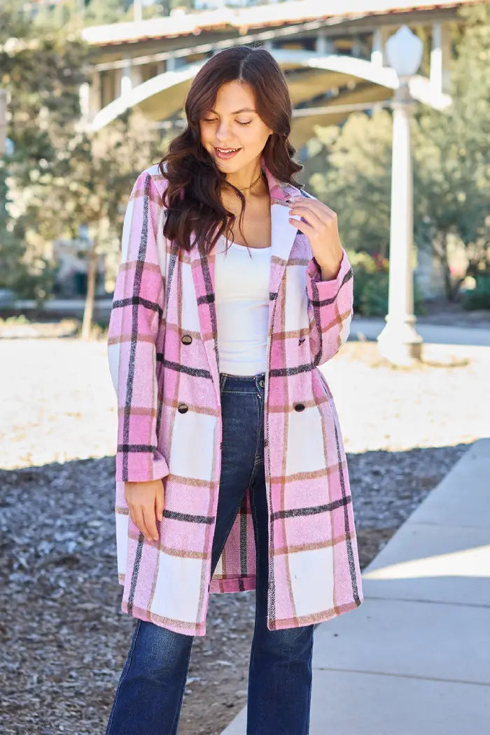 Woman in a Pink plaid wool coat with button closure front view, styled with jeans and a white top in an outdoor setting.
