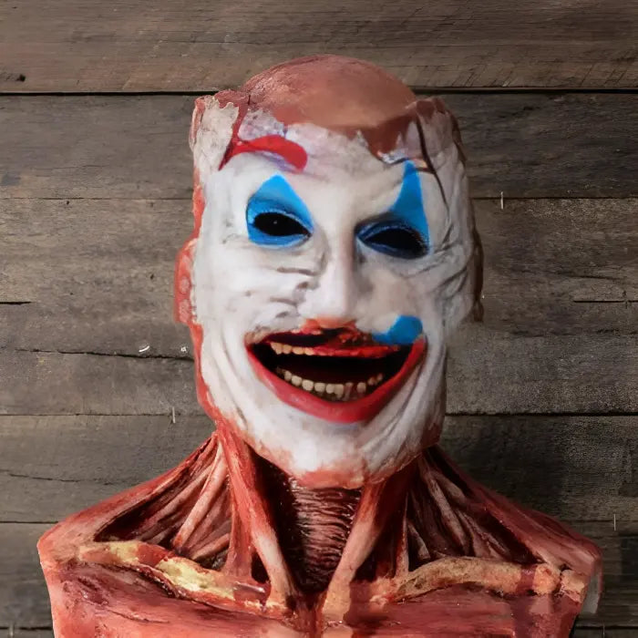 Realistic Halloween mask featuring muscle tissue and Joker-style clown face against wood backdrop.