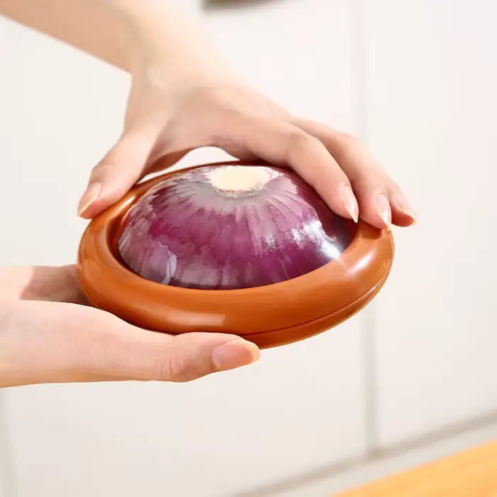 red onion storage container with retractable membrane being held to demonstrate size and proper usage for halved produce