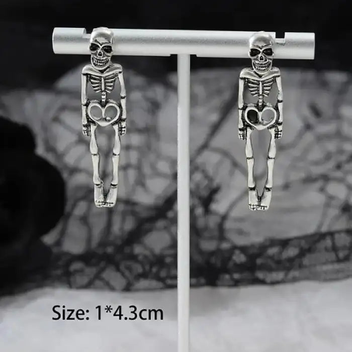 Silver skeleton earrings pair on display stand with dangling body detail and size dimensions shown.
