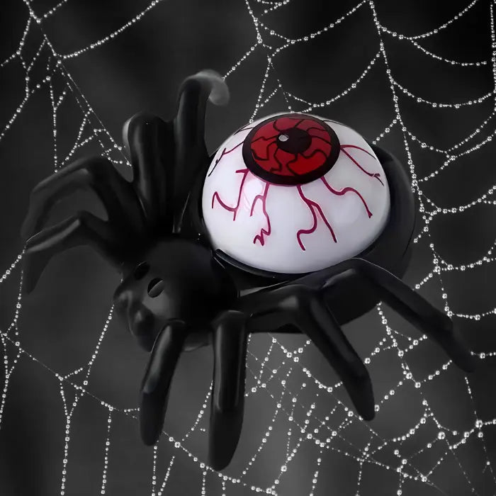 Red eyeball spider candle on spooky spiderweb background for Halloween theme.
