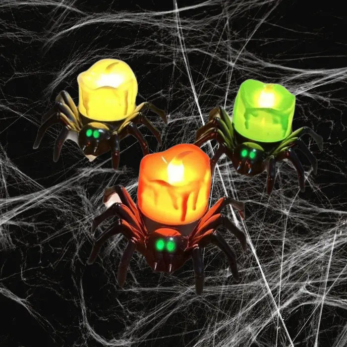 Trio of green, red, and yellow LED spider candles on dark cobweb background for Halloween.