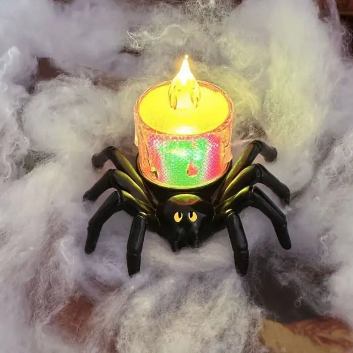 Color-shifting spider candle with rainbow LED flame in Halloween cobweb setting.