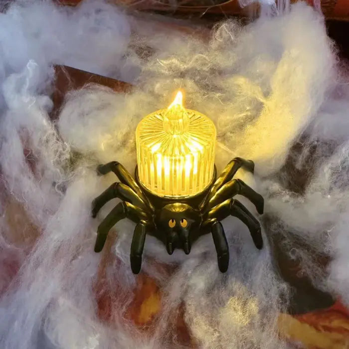 Spider candle holder with glowing yellow glass flame on spooky cobweb background.