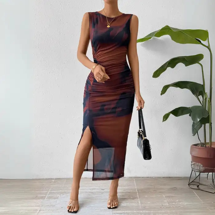 Tie dye maxi dress in brown with a form-fitting design and side slit, styled with clear heels.