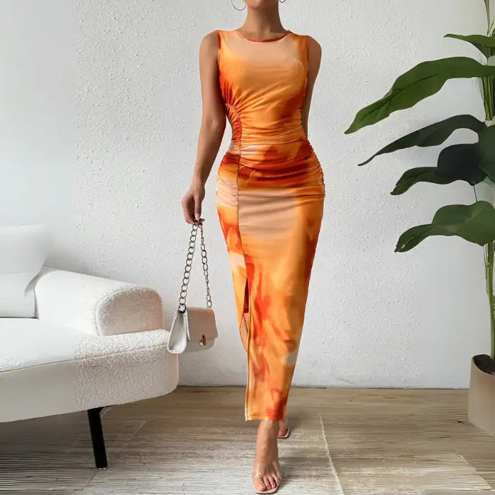 Orange tie dye maxi dress with a form-fitting silhouette, sleeveless design, and side slit.