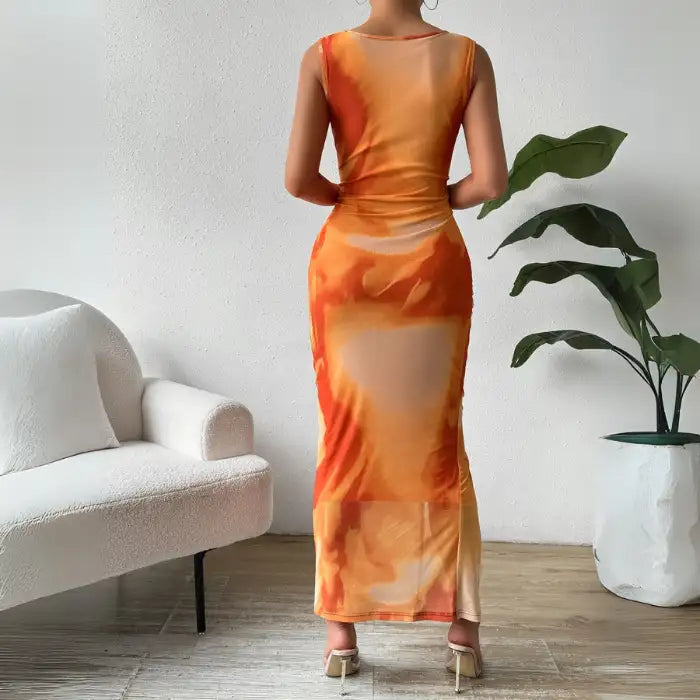 Orange tie dye maxi dress with a ruched, form-fitting design, styled for summer occasions.