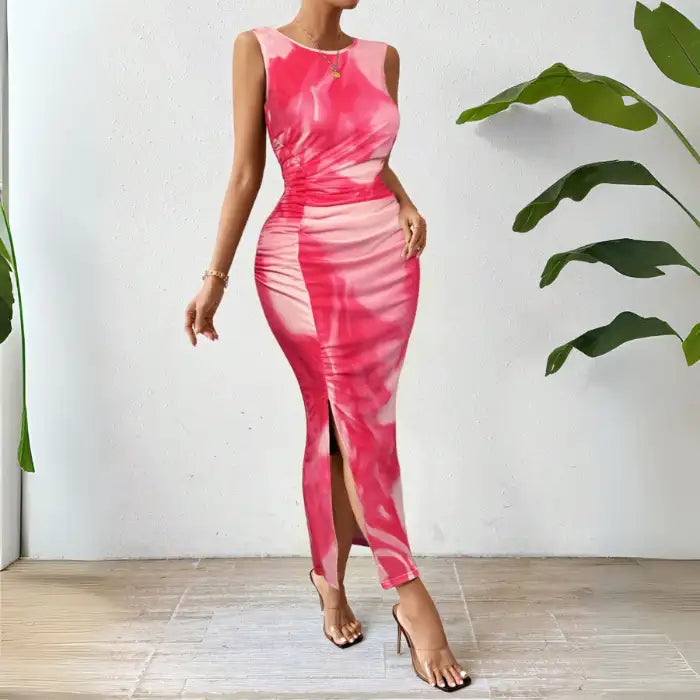 Pink tie dye maxi dress featuring a form-fitting design, ruched sides, and a side slit.
