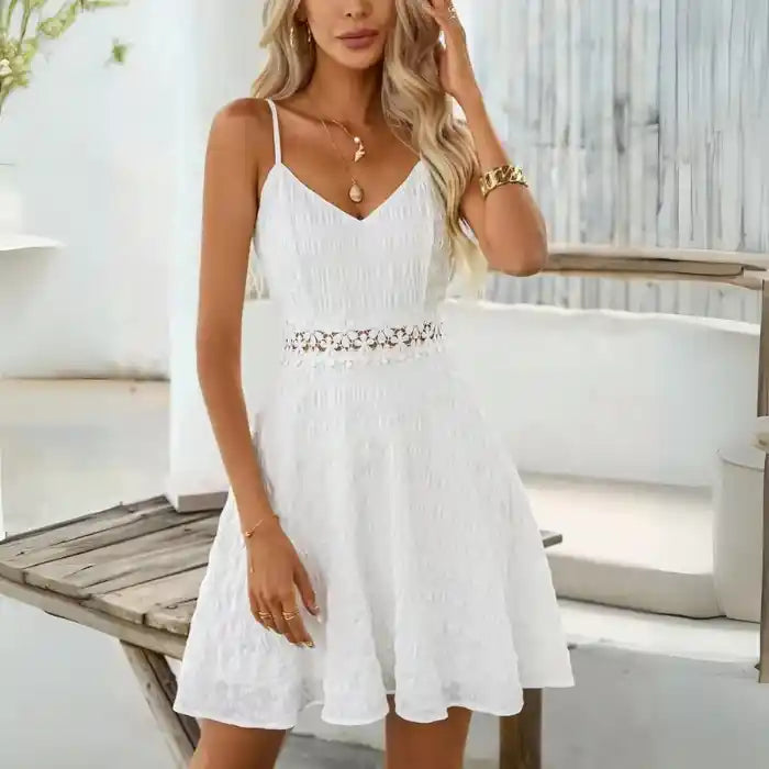 White crochet spaghetti strap dress next to pink flowers for a chic summer vibe