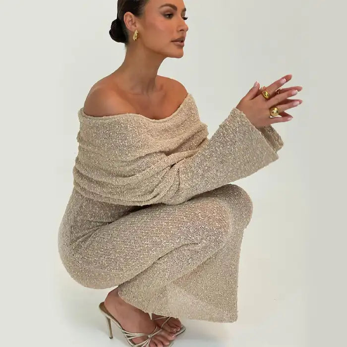 Women's one-shoulder long-sleeve knitted vacation dress in neutral beige worn with gold heels.