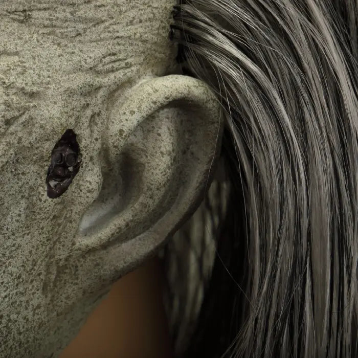Zombie face mask with decaying ear hole and gray hair, showing realistic undead texture.