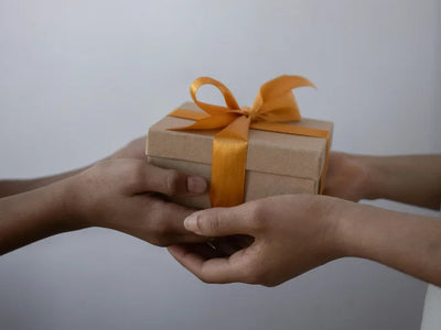 close up of passing a gift box from one person to another