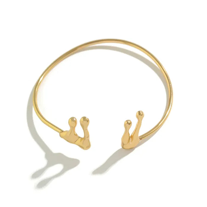 Gold bracelet with snail designs on a white background