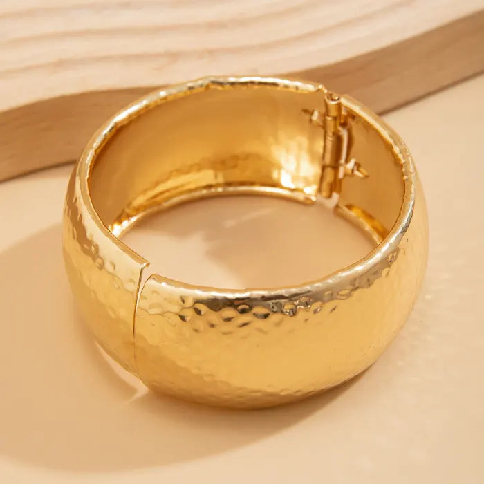 Gold bracelet on a beige background