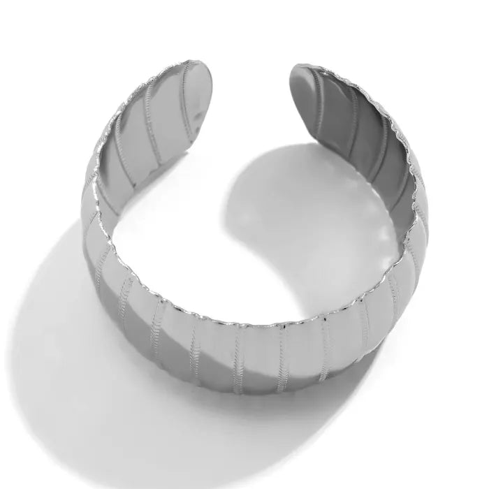 Silver ring with a textured band on a white background