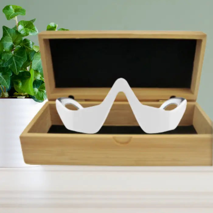  3-in-1 eye rejuvenation device neatly displayed in a wooden case with black velvet interior.