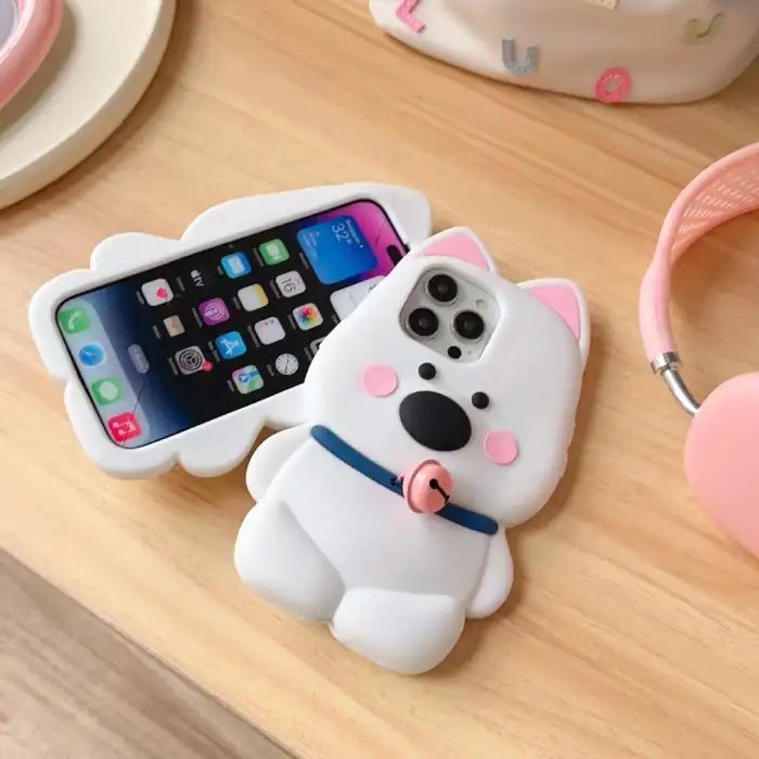 3D animal phone case shaped like a white dog with pink ears, a blue collar, and a pink bell.