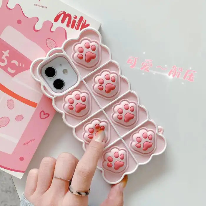 3D silicone phone case with pink cat paw design showing textured toe beans and scalloped border for iPhone protection