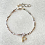Silver bracelet with a letter 'P' charm on a light gray background