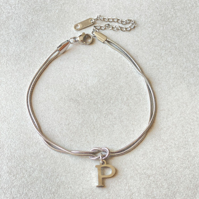 Silver bracelet with a letter 'P' charm on a light gray background