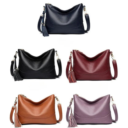 Collection of leather handbags in blue, black, red, brown, and purple with tassels.